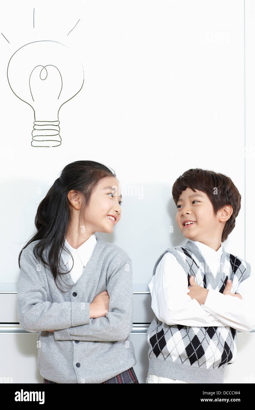 girl and boy student standing with arms crossed smiling at each other Stock Photo