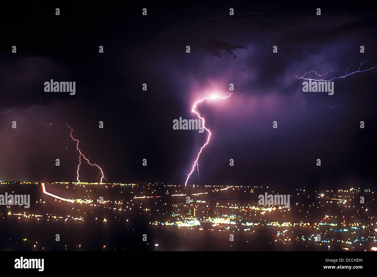 Lightning strikes at night over city lights Stock Photo - Alamy