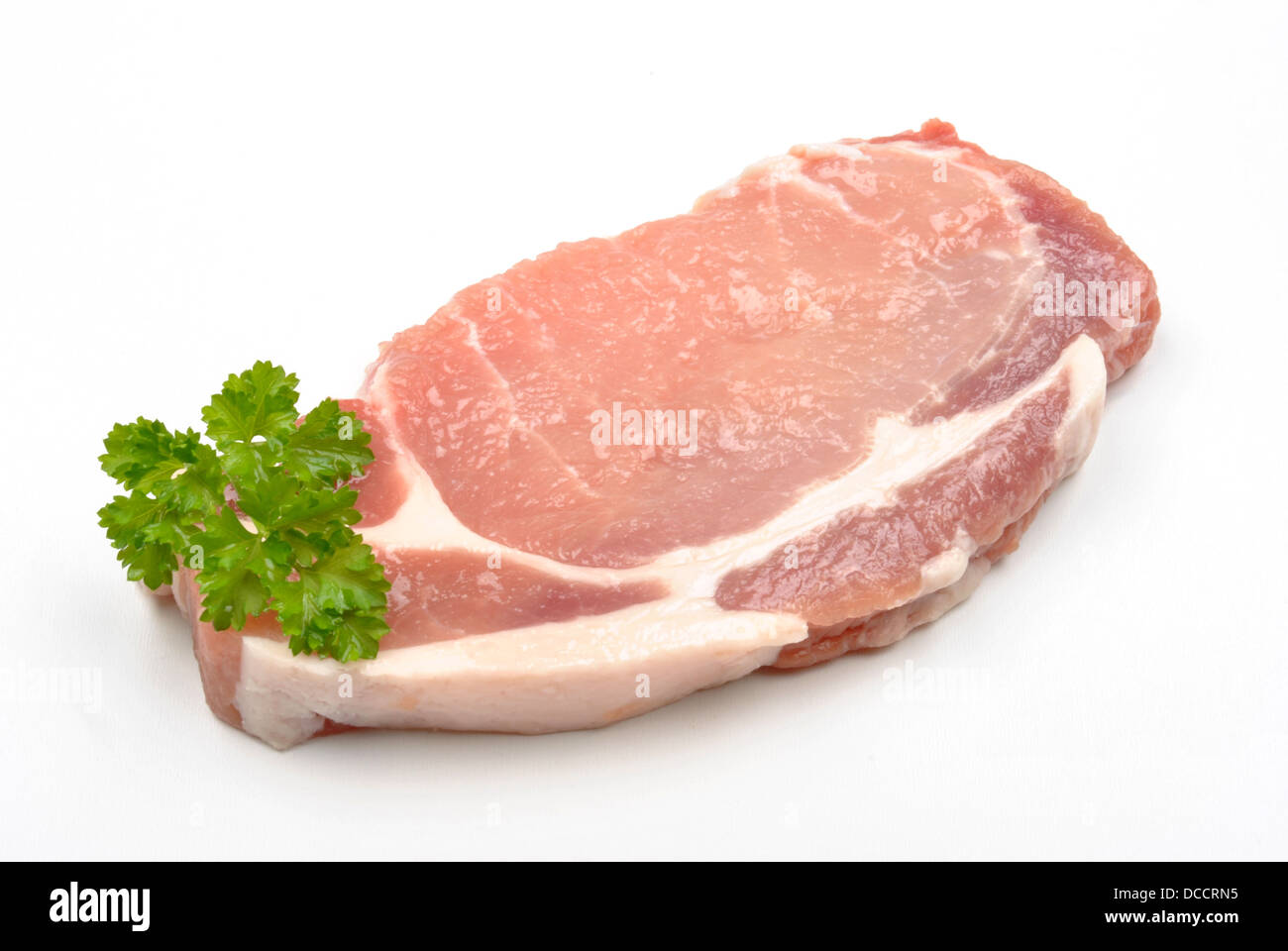 one raw organic pork chop and parsley Stock Photo