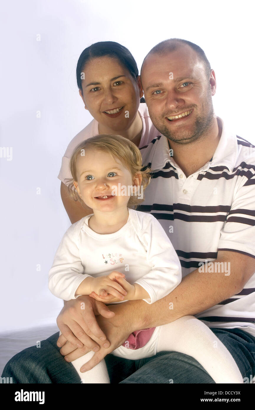 young-couple-sitting-with-a-3-year-old-girl-studio-stock-photo-alamy