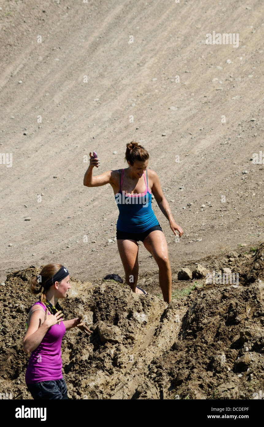 Woman prepares to step on muddy slide in 5k Mud run. Stock Photo