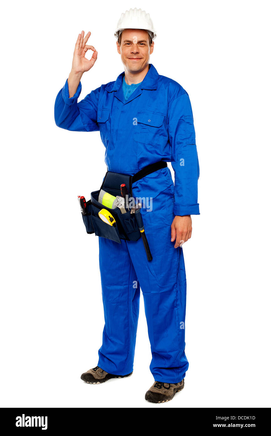 Full length portrait of construction worker gesturing okay sign, carrying tools bag Stock Photo