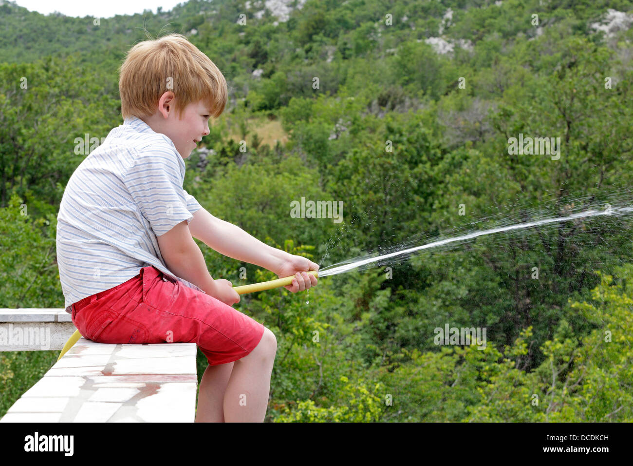 portrait of a young boy boy watering the garden Stock Photo