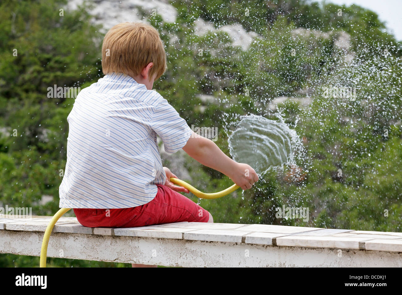 portrait of a young boy boy watering the garden Stock Photo