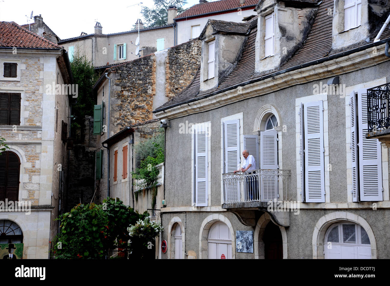 Man standing on balcony of building in the medieval town of Puy L'Eveque in the Lot Region or Department of France Stock Photo