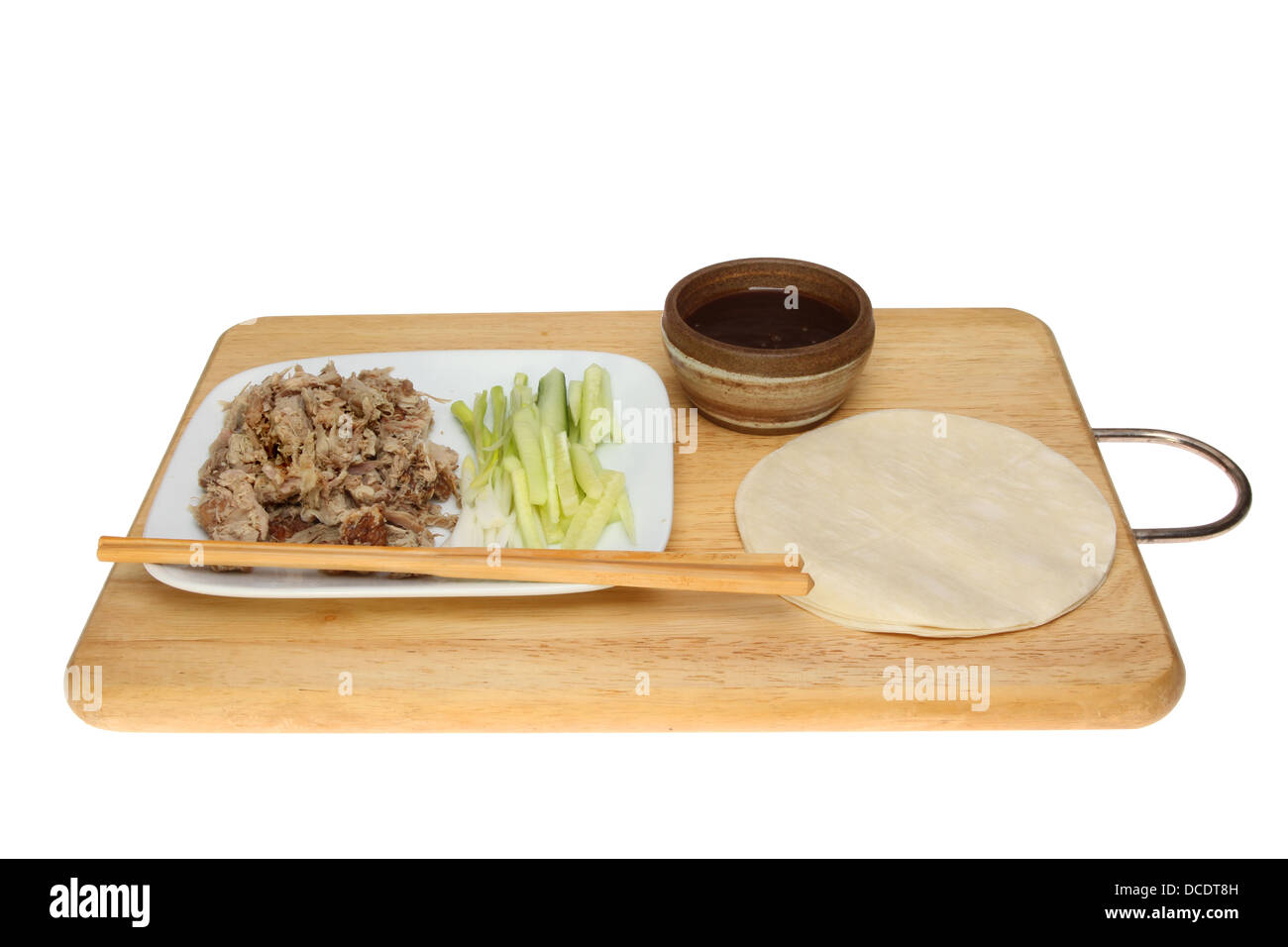 Chinese crispy duck pancake ingredients on a wooden board isolated against white Stock Photo
