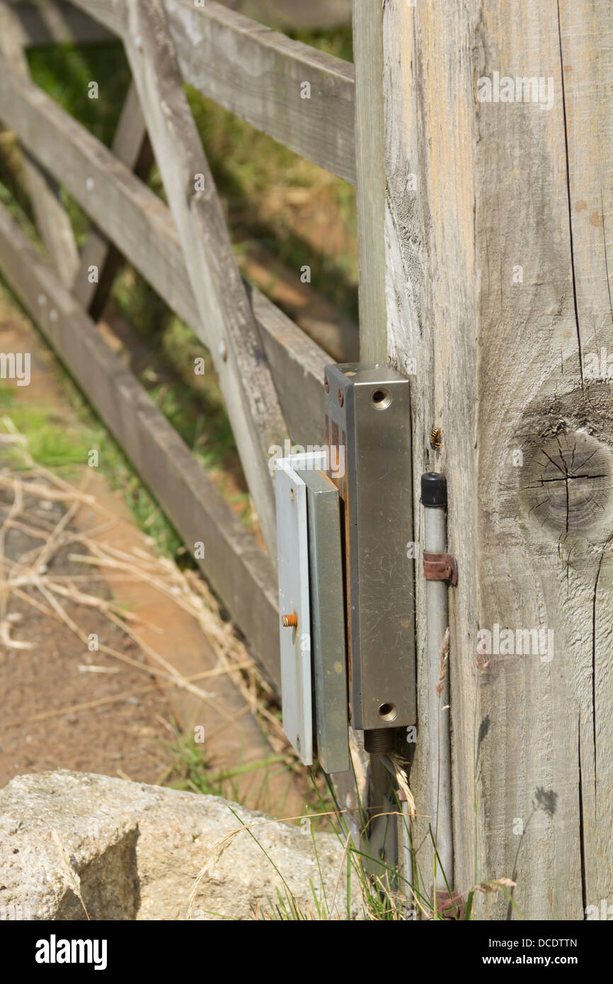 Electro-magnetic lock on on an outside wooden gate. The lock is connected to a nearby intercom to enable remote release. Stock Photo