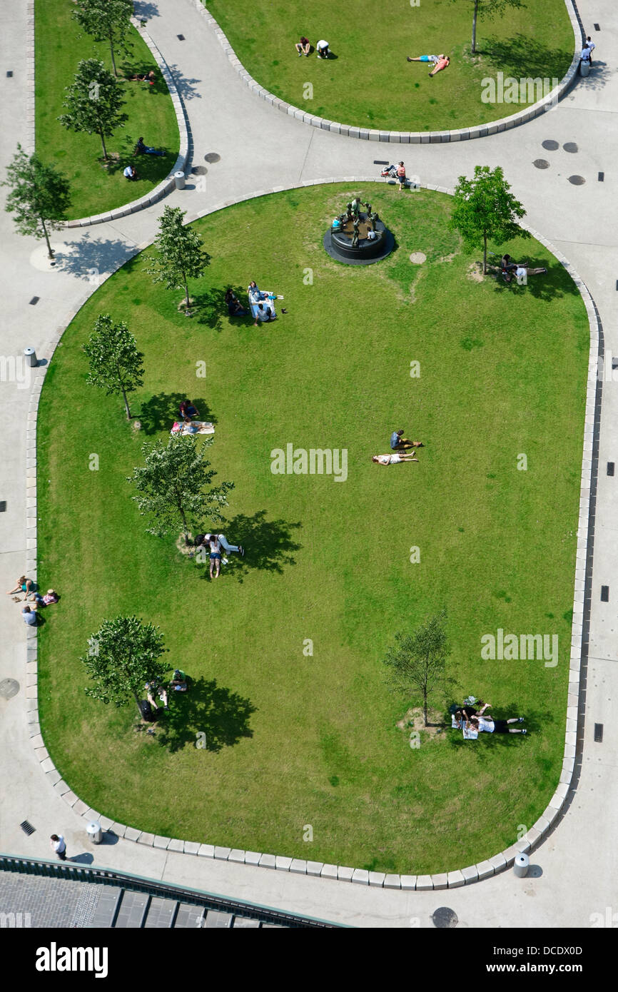 Aerial view on people sunning and sitting in the shadow of trees in small green city park on a hot day in summer, Ghent, Belgium Stock Photo