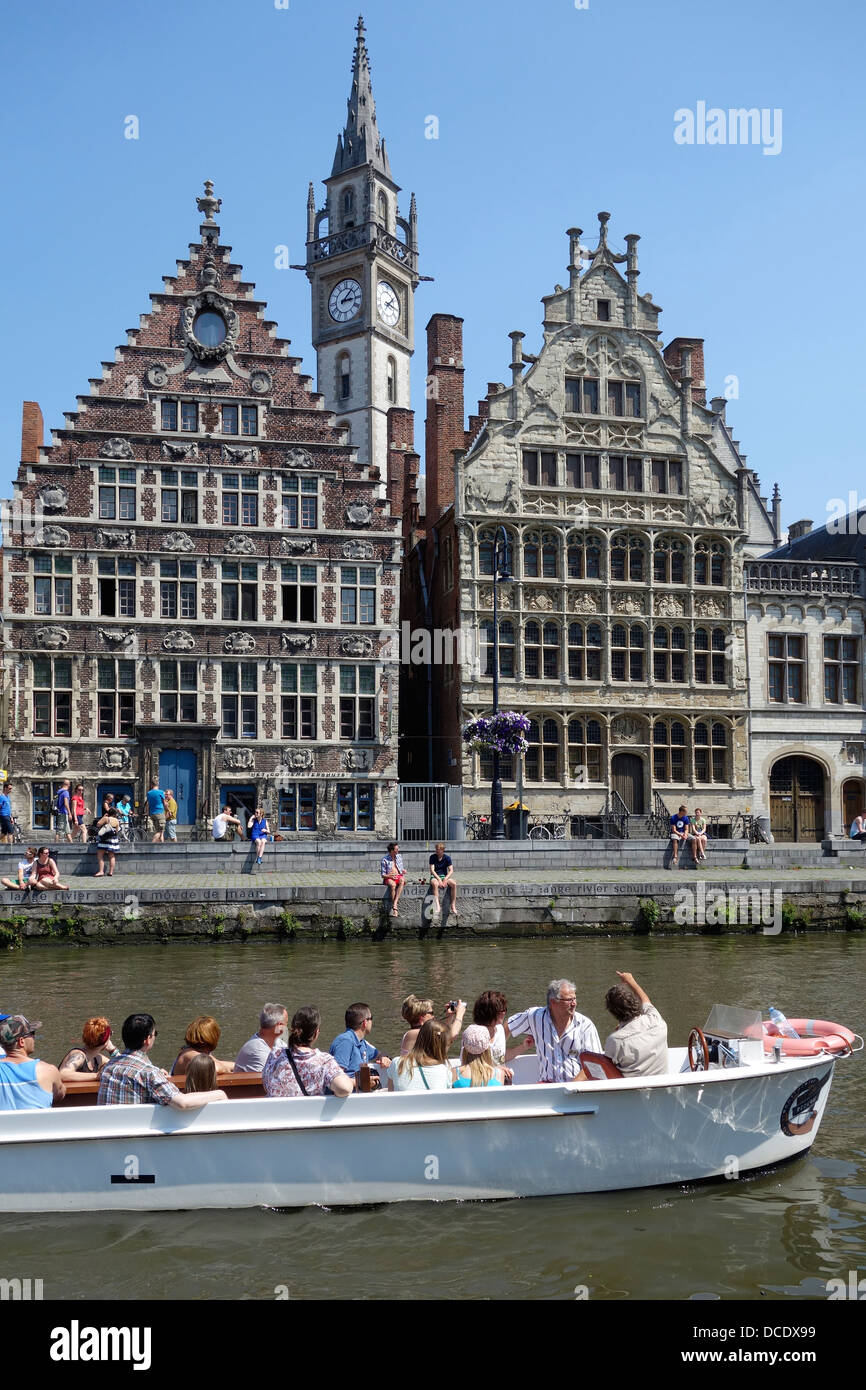 Sightseeing boat with tourists on the river Lys with view over guildhalls at Graslei / Grass Lane at Ghent, Flanders, Belgium Stock Photo