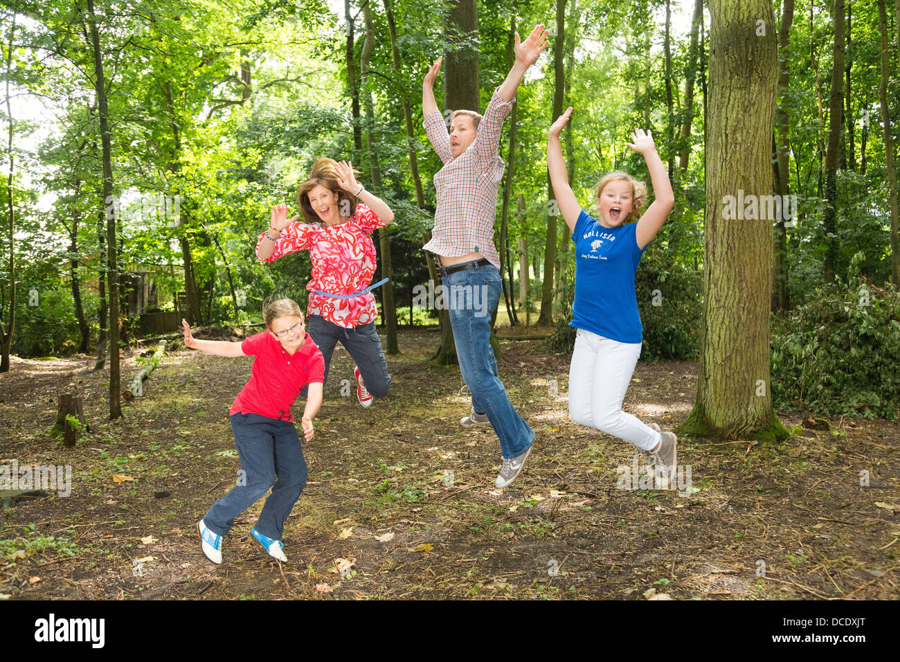 family jumping up in the air outdoors Stock Photo