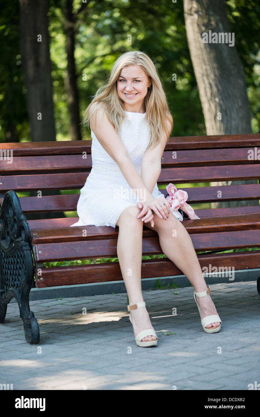 Young woman sitting on the bench in park Stock Photo - Alamy