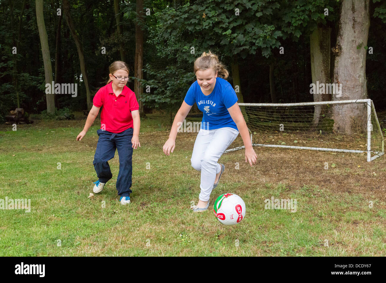 two young girls playing soccer in backyard/garden Stock Photo