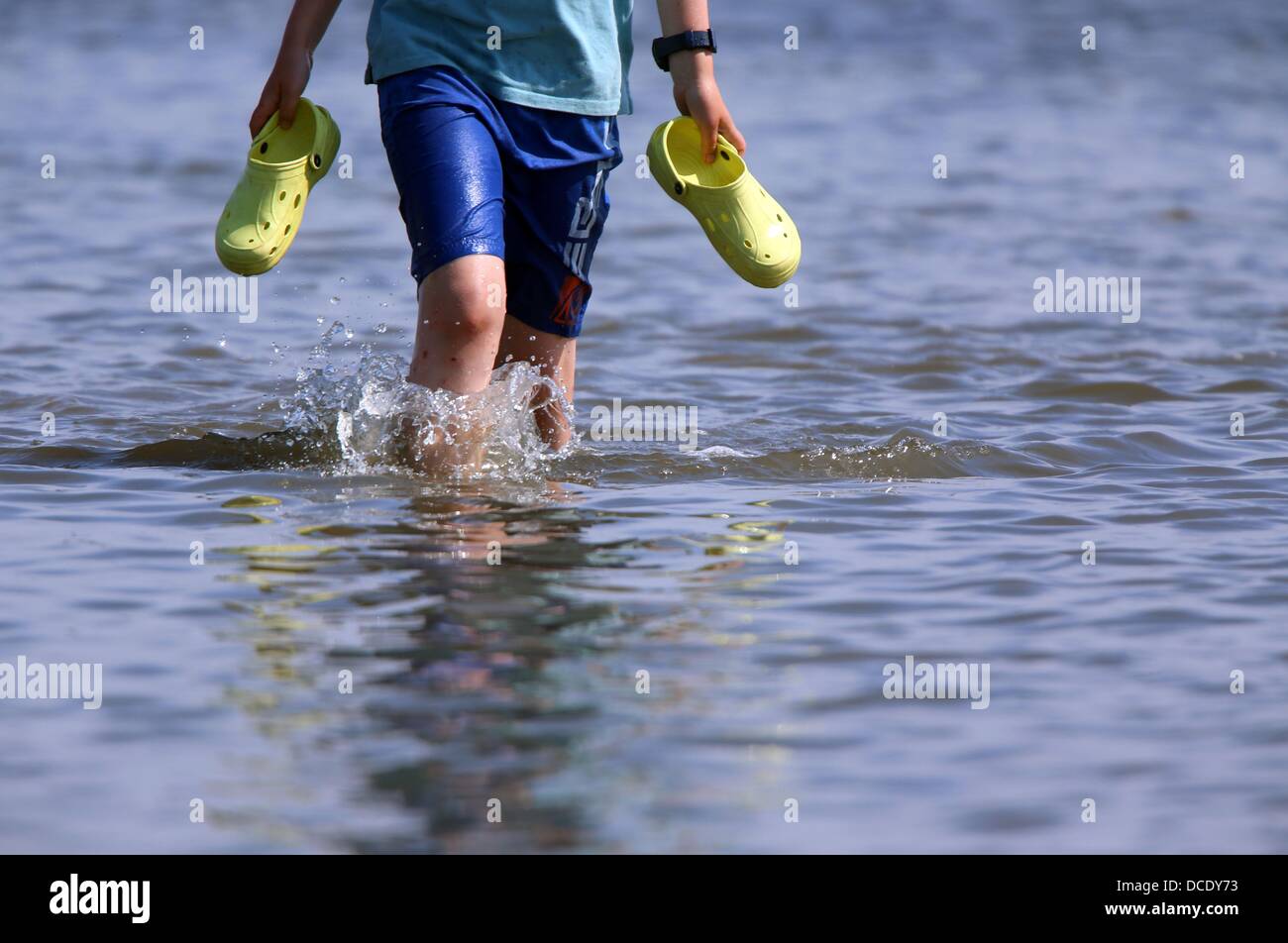 People wade through the water from the ferry "MS Salzhaff" to reach the