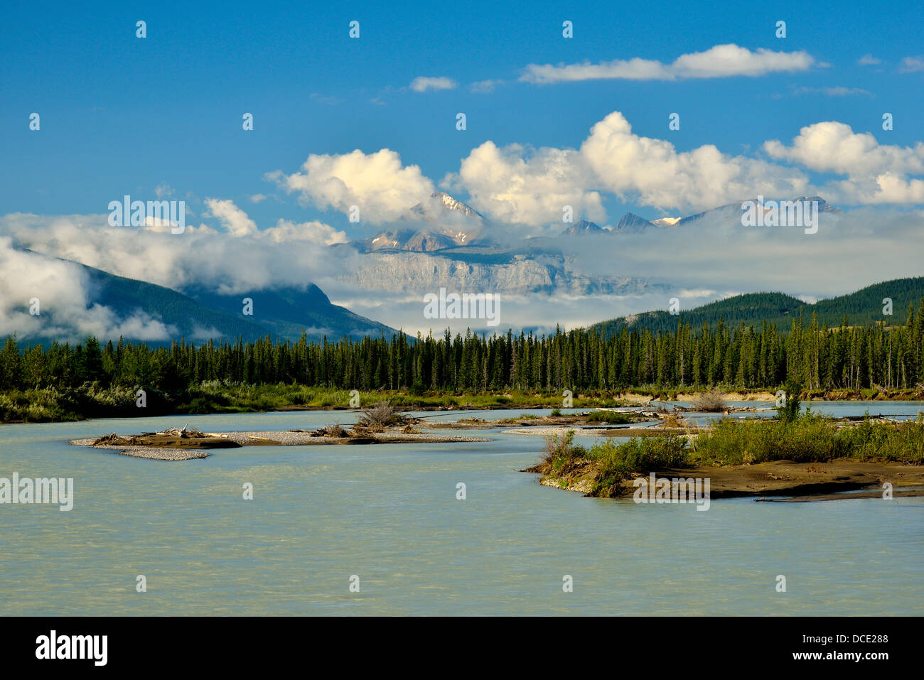 The Athabasca river with Pyramid mountain slightly hidden by clouds in Jasper National Stock Photo