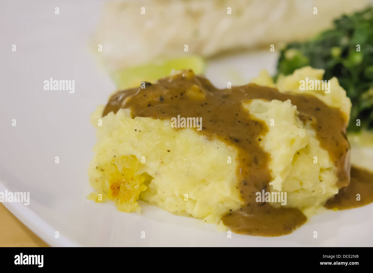 close up Mashed potato with gravy on white dish Stock Photo