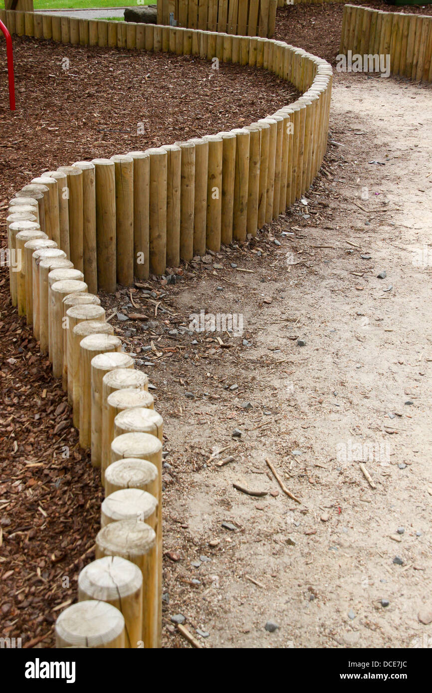 Curved wooden log fence in playground Stock Photo