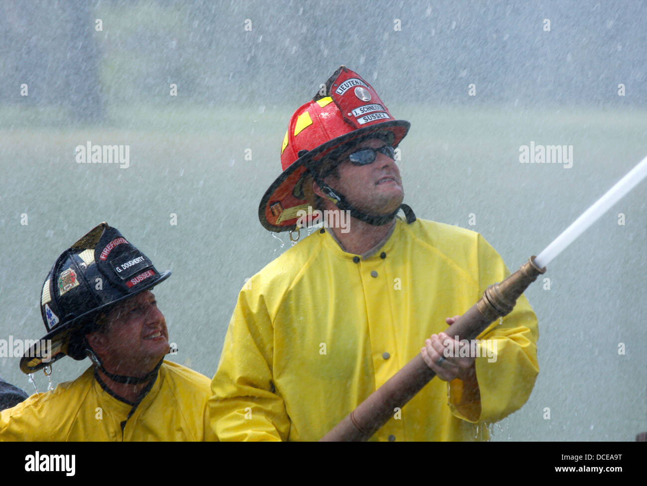 Fireman spraying water from hose hires stock photography and images