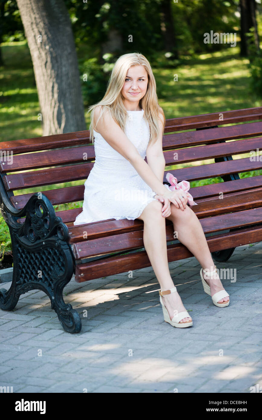 Young woman sitting on the bench in park Stock Photo - Alamy