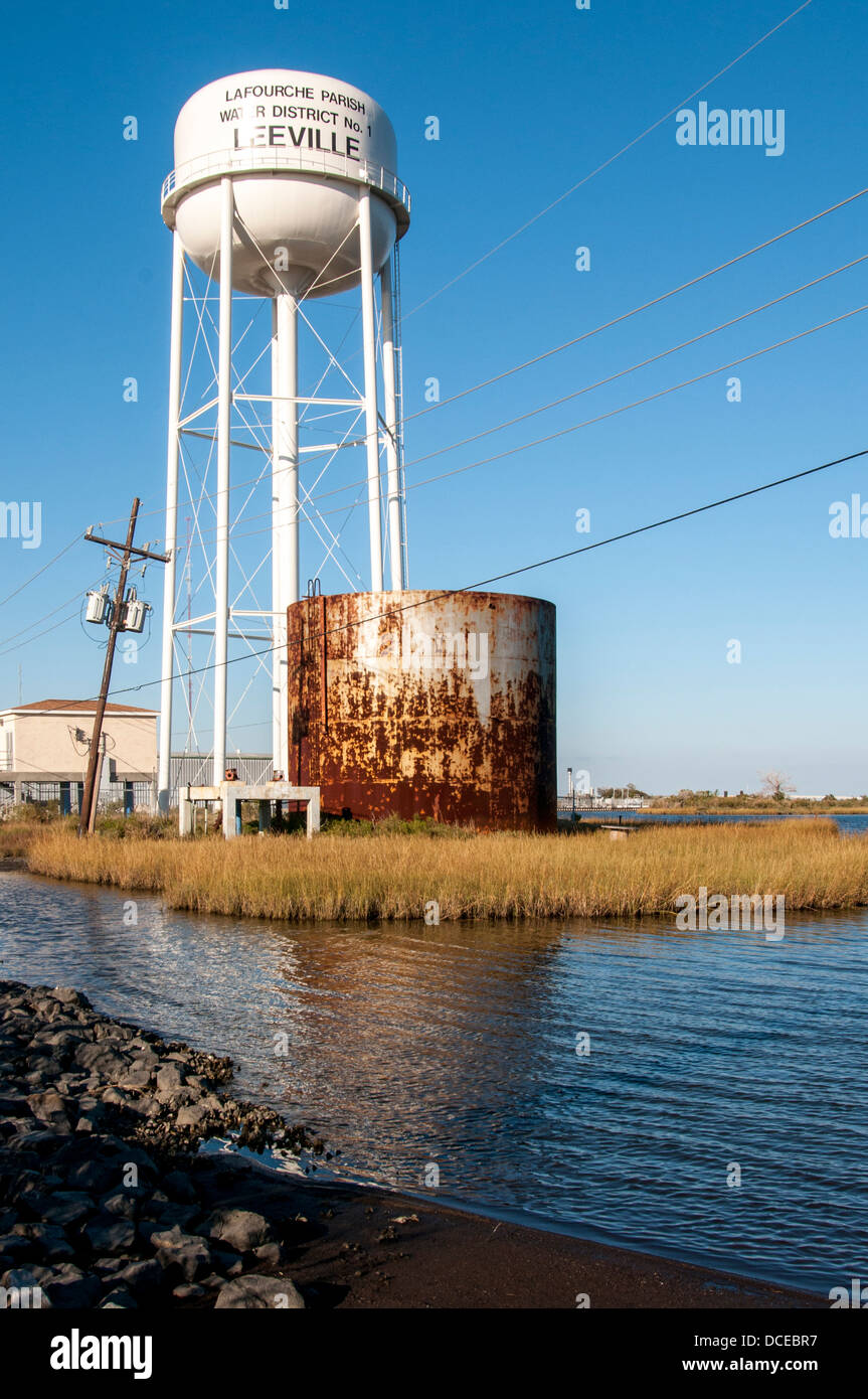 USA, Louisiana, Atchafalaya Basin, Leeville, water tower, old rusted storage tank, and telephone pole askew. Stock Photo