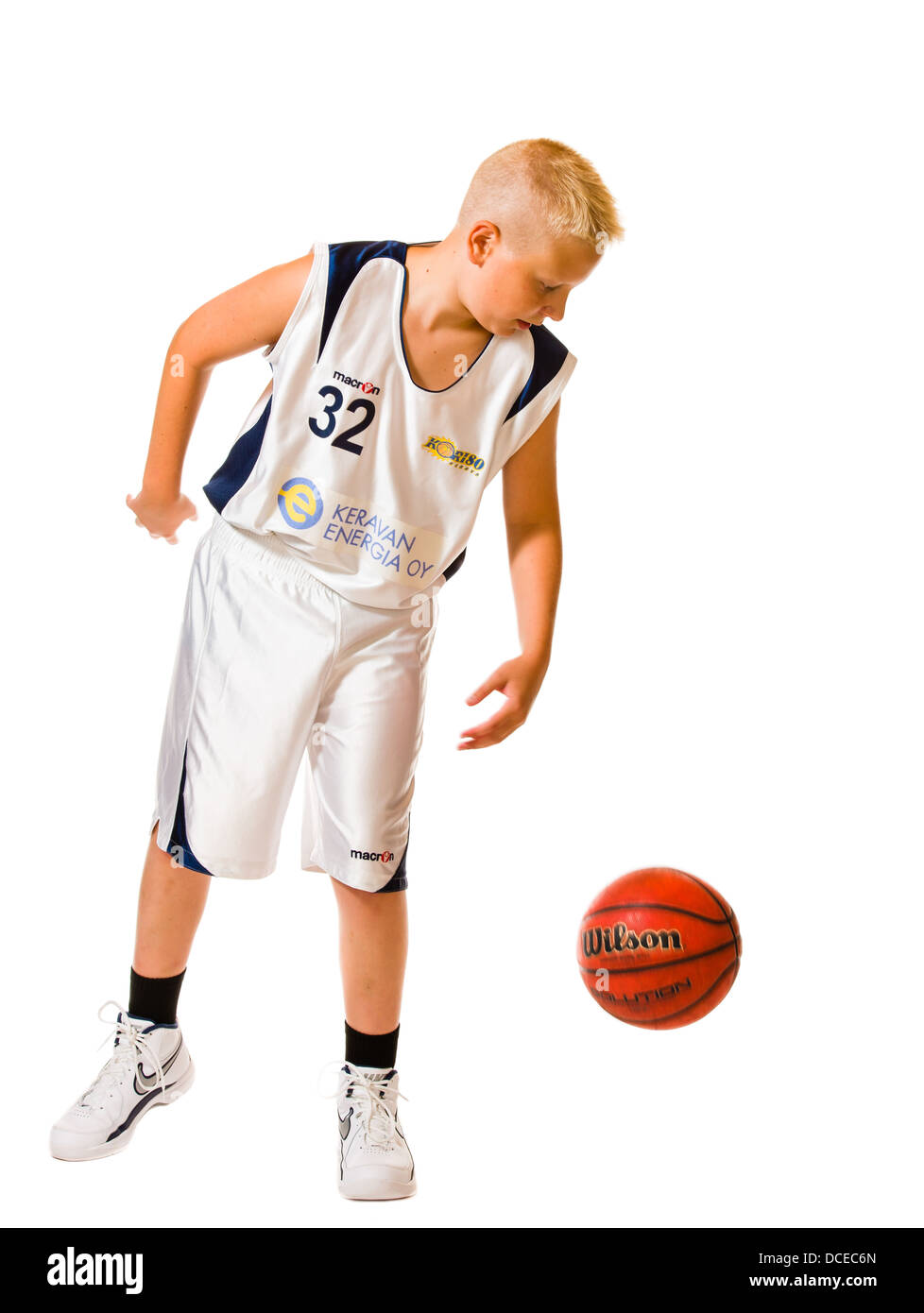 Young basketball player wearing white team uniform, studio shot, white