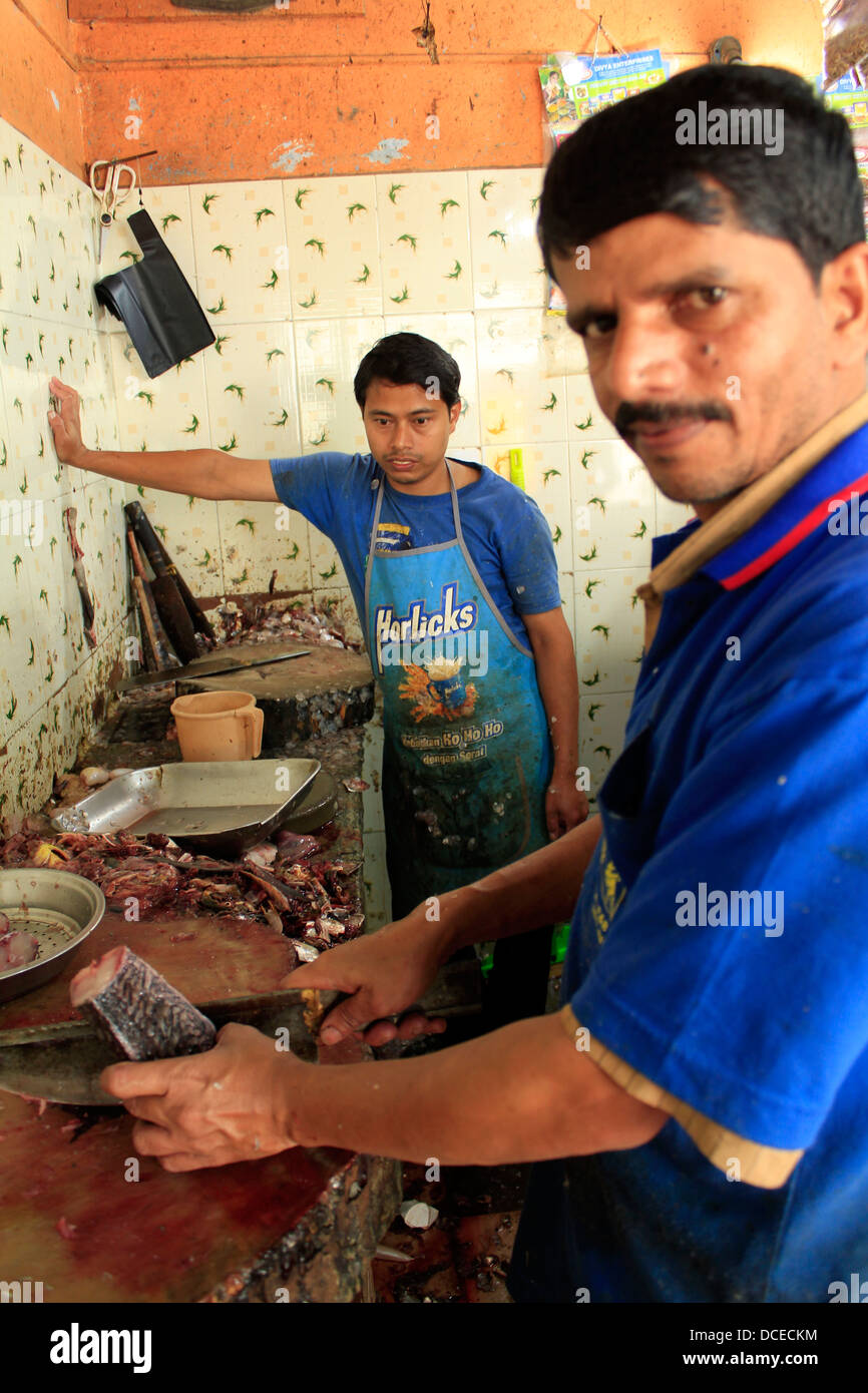 Indian man cleaning fish at a local fish market in bangalore Stock Photo