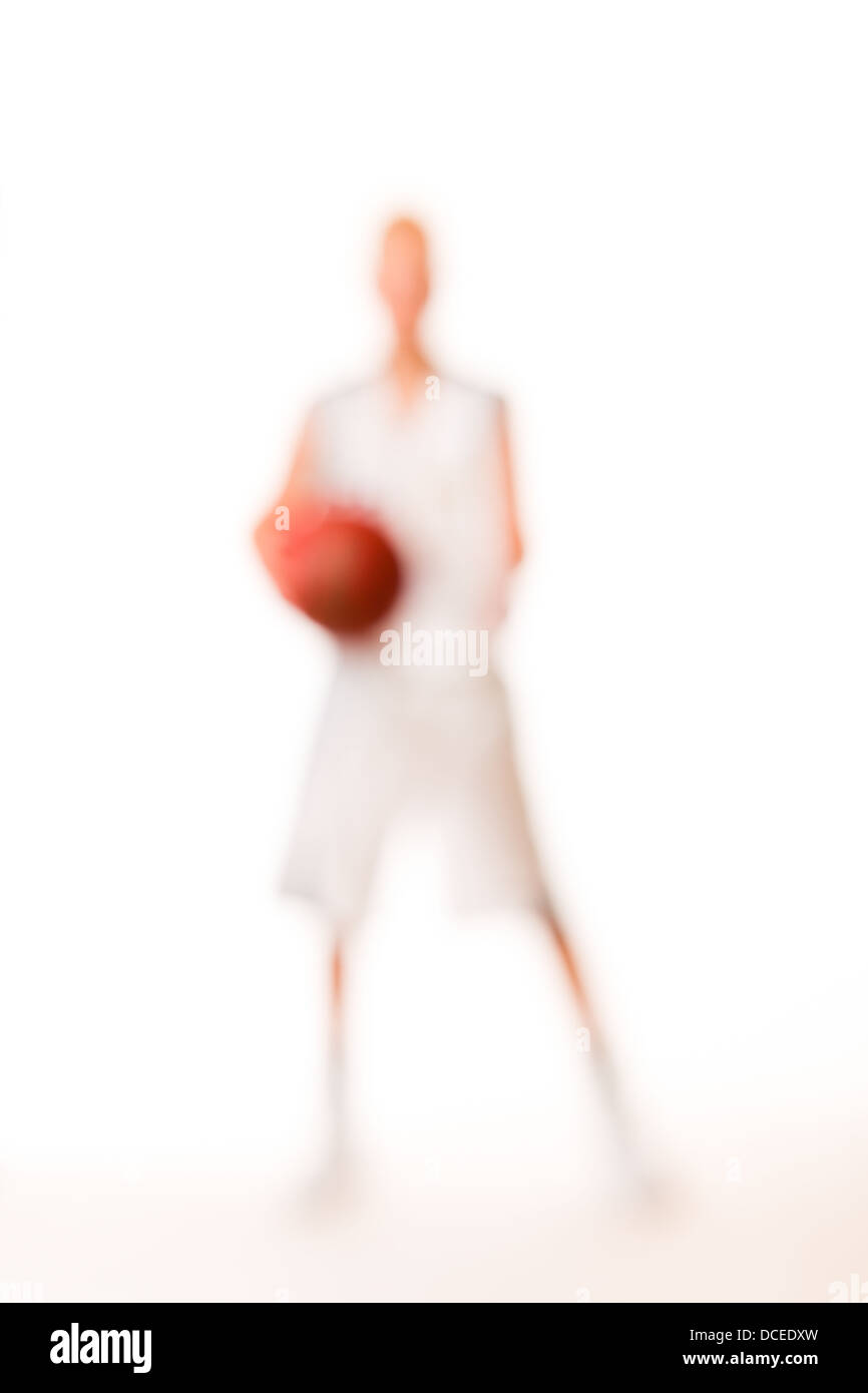 Young basketball player wearing white team uniform, studio shot, white