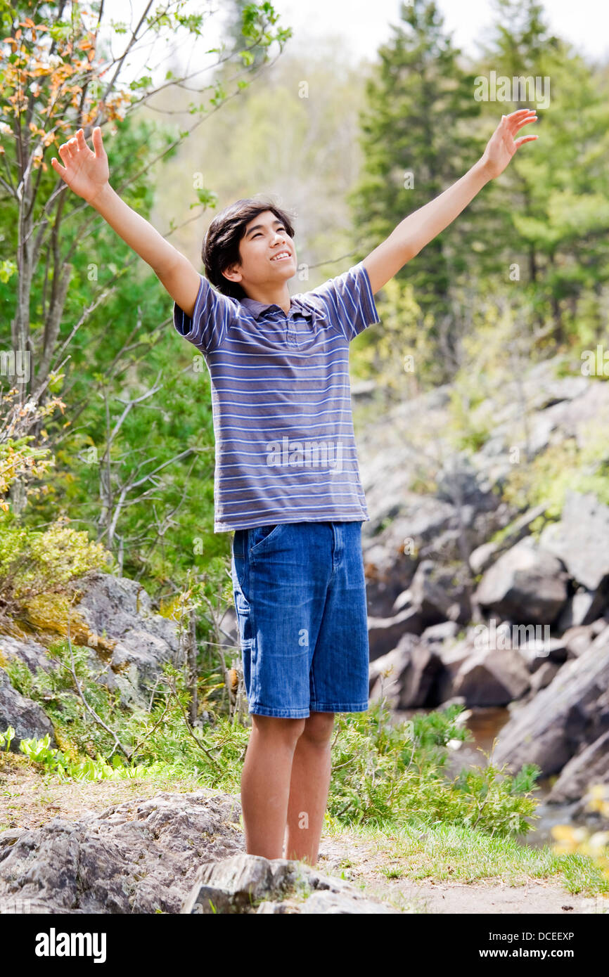 Teenage boy raising hands in praise Stock Photo - Alamy
