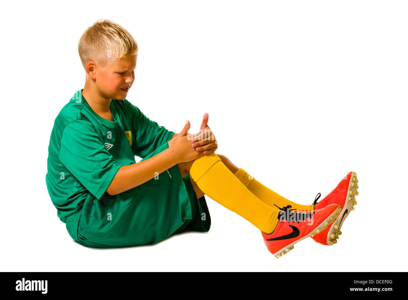 Young football player injured on his knee, studio shot, white background Stock Photo