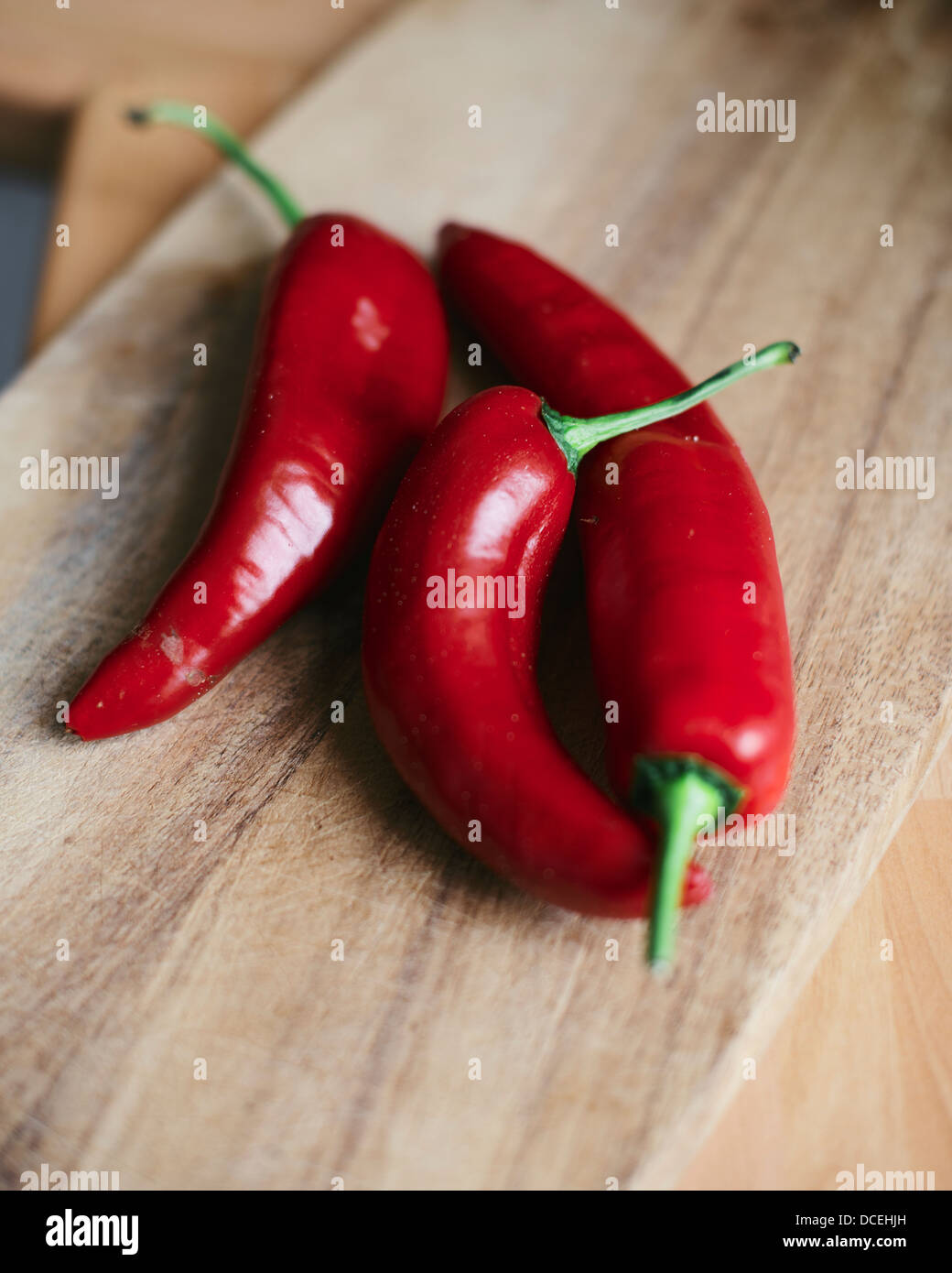 Red Chili peppers on Chopping board Stock Photo - Alamy