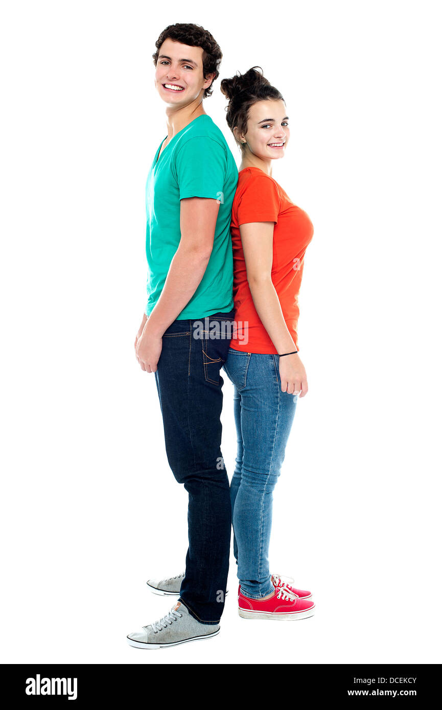 Full length portrait of an adorable young couple posing back to back ...