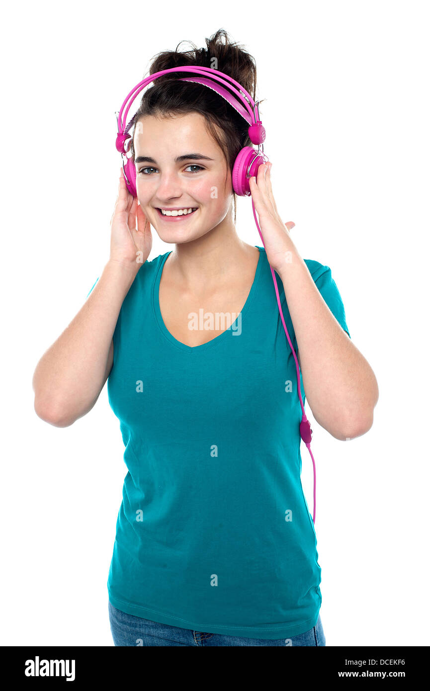 Cheerful pretty girl listening to music through headphones Stock Photo ...
