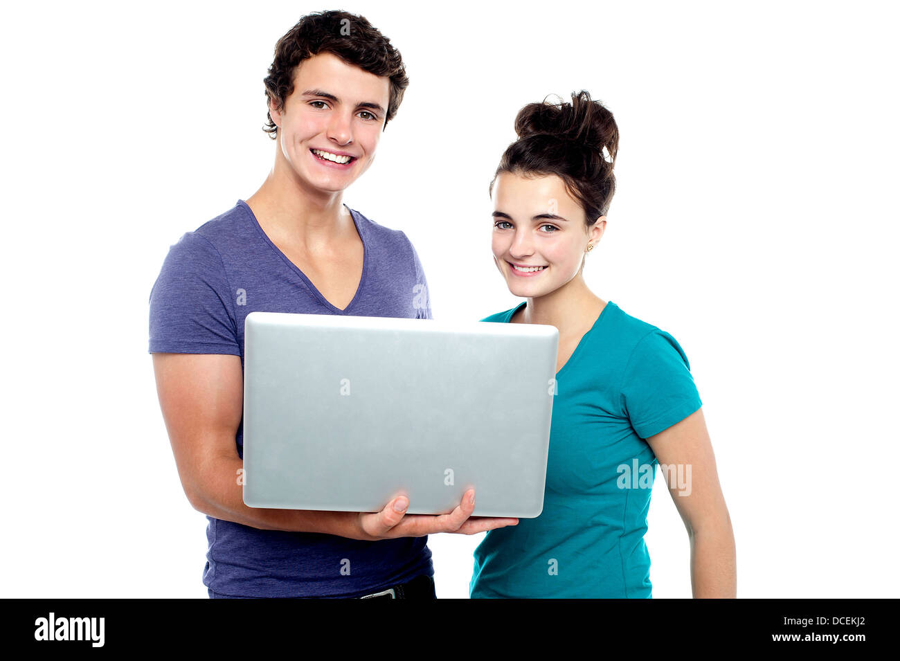 Charming teen couple holding a laptop isolate against white background ...