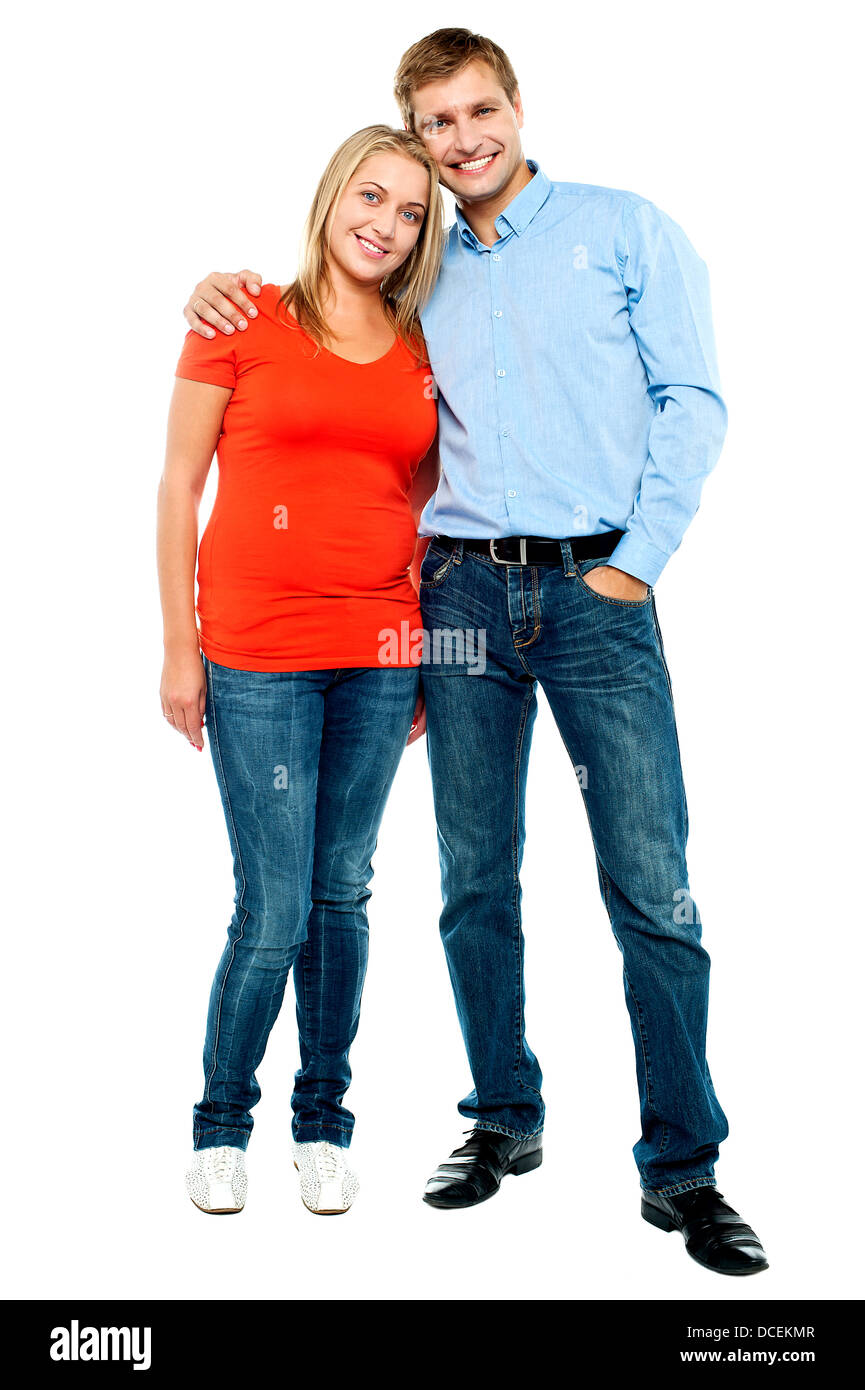 Portrait of happy young couple hugging at studio. Full length shot ...