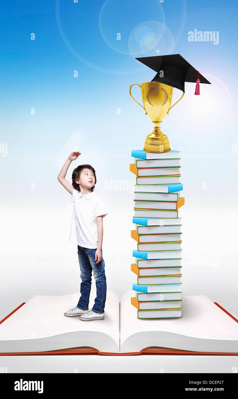 a boy standing next to a pile of books Stock Photo - Alamy