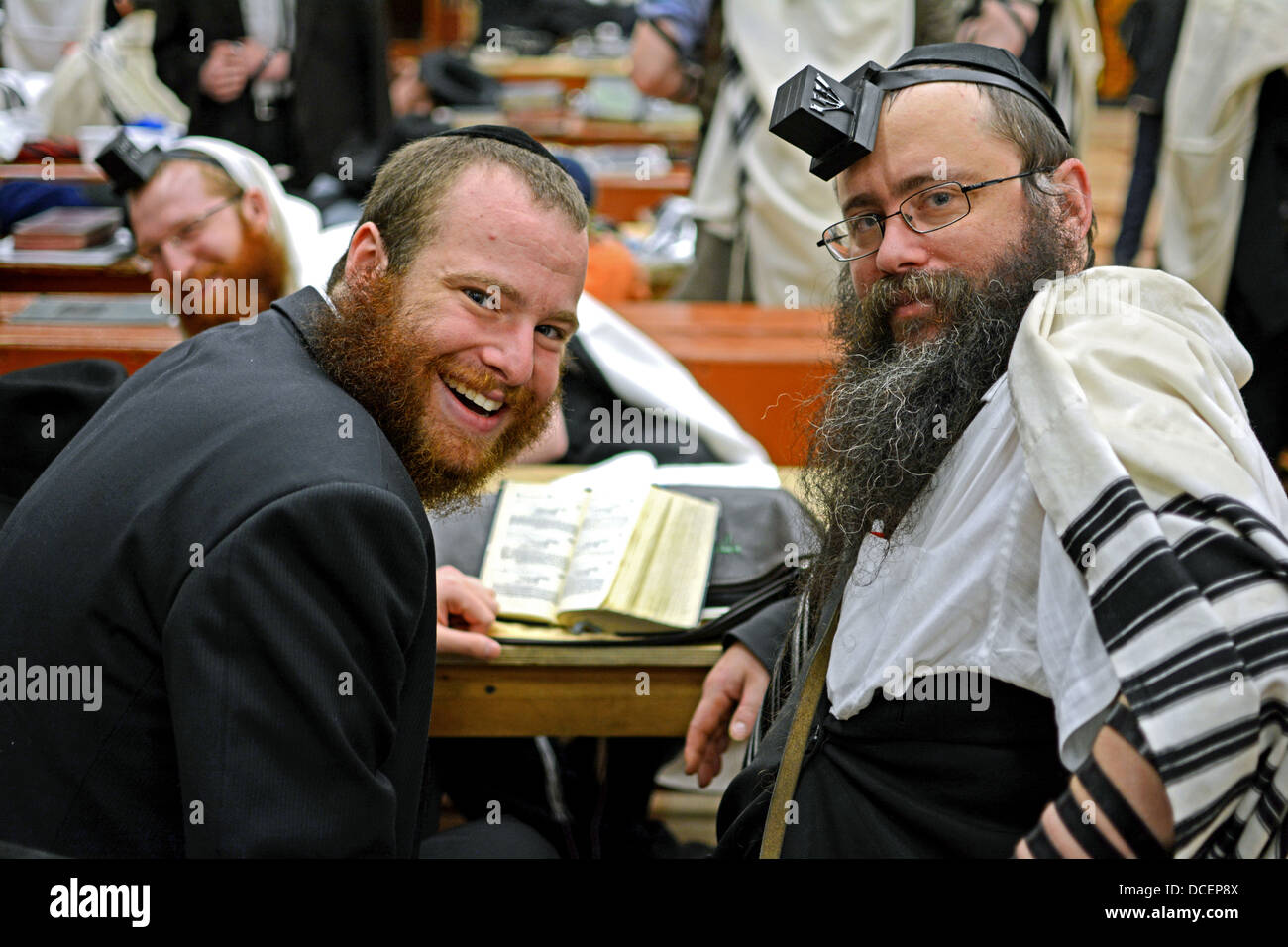 Portrait of 2 religious Jewish men while a 3rd tries hiding in the background. In Crown Heights, Brooklyn, New York Stock Photo
