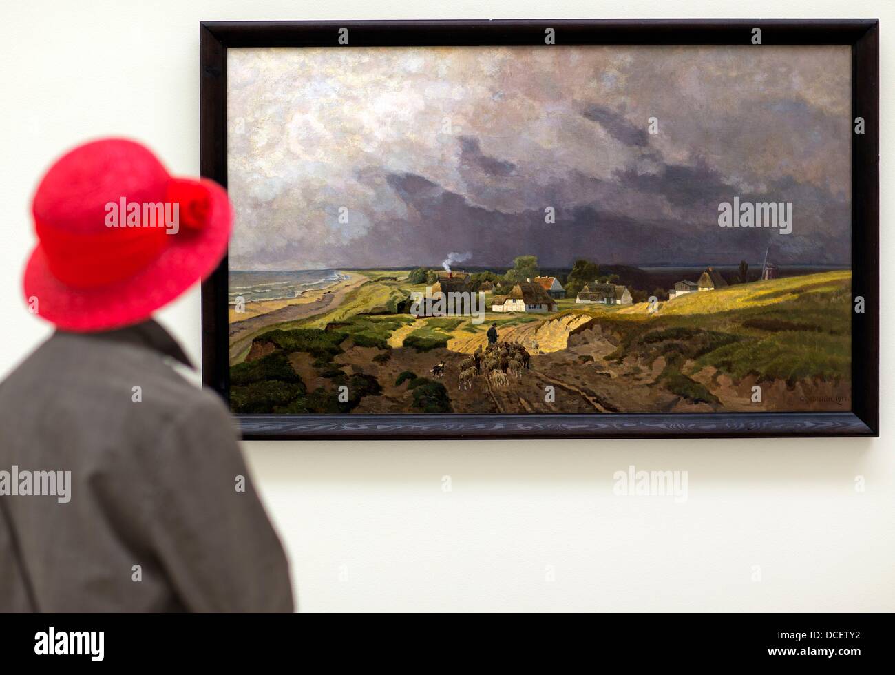 A woman looks at the painting 'Gewitterstimmung ueber Ahrenshoop' by Carl Malchin in the new art museum on the Fischland-Darss-Zingst penisula on civic day in Ahrenshoop, Germany, 16 August 2013. The new museum opens on 30 August 2013. Photo: JENS BUETTNER Stock Photo