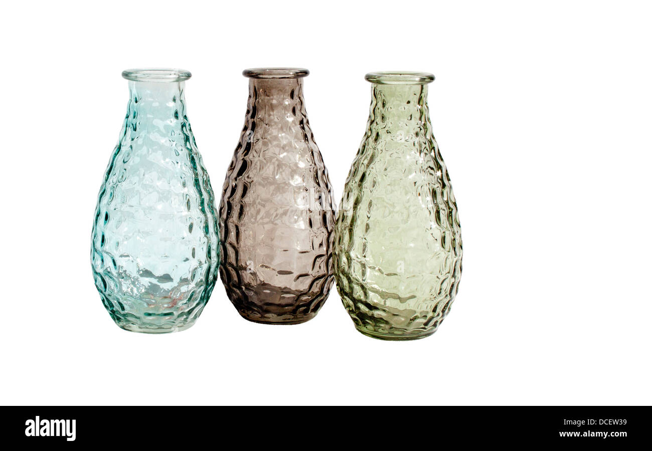 A set of three differently colored transparent glass vases on an isolated white background Stock Photo