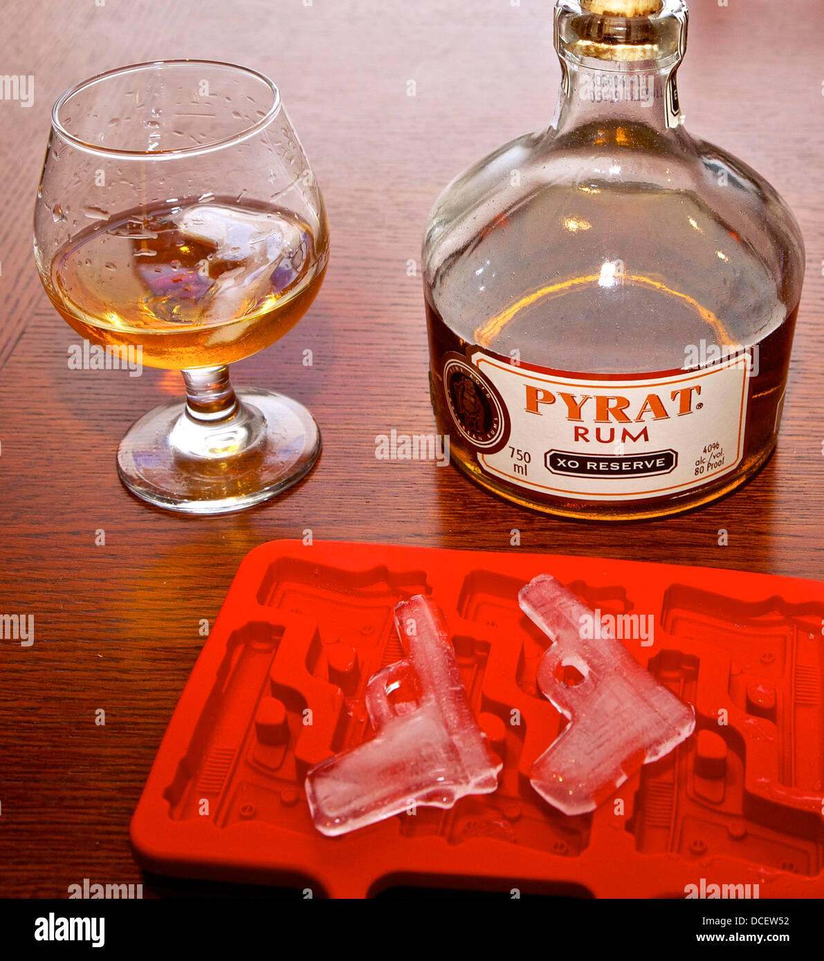 Bottle and snifter of Pyrat rum and gun shaped ice cubes Stock Photo