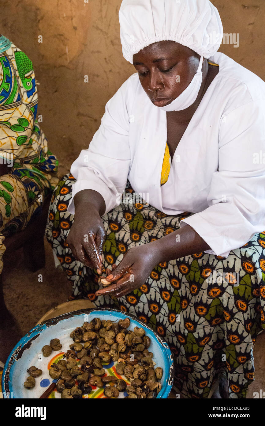 Woman Hulling Cashew Nuts at Cashew Nut Processing Center, Group Dimbal Djabott, Mendy Kunda, North Bank Region, The Gambia Stock Photo