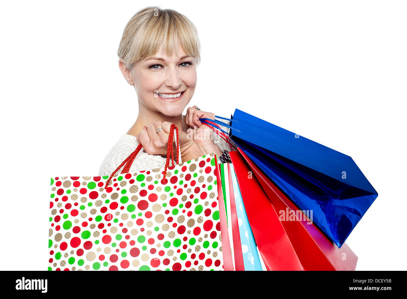 Pretty female carrying shopping bags over shoulders, studio shot Stock