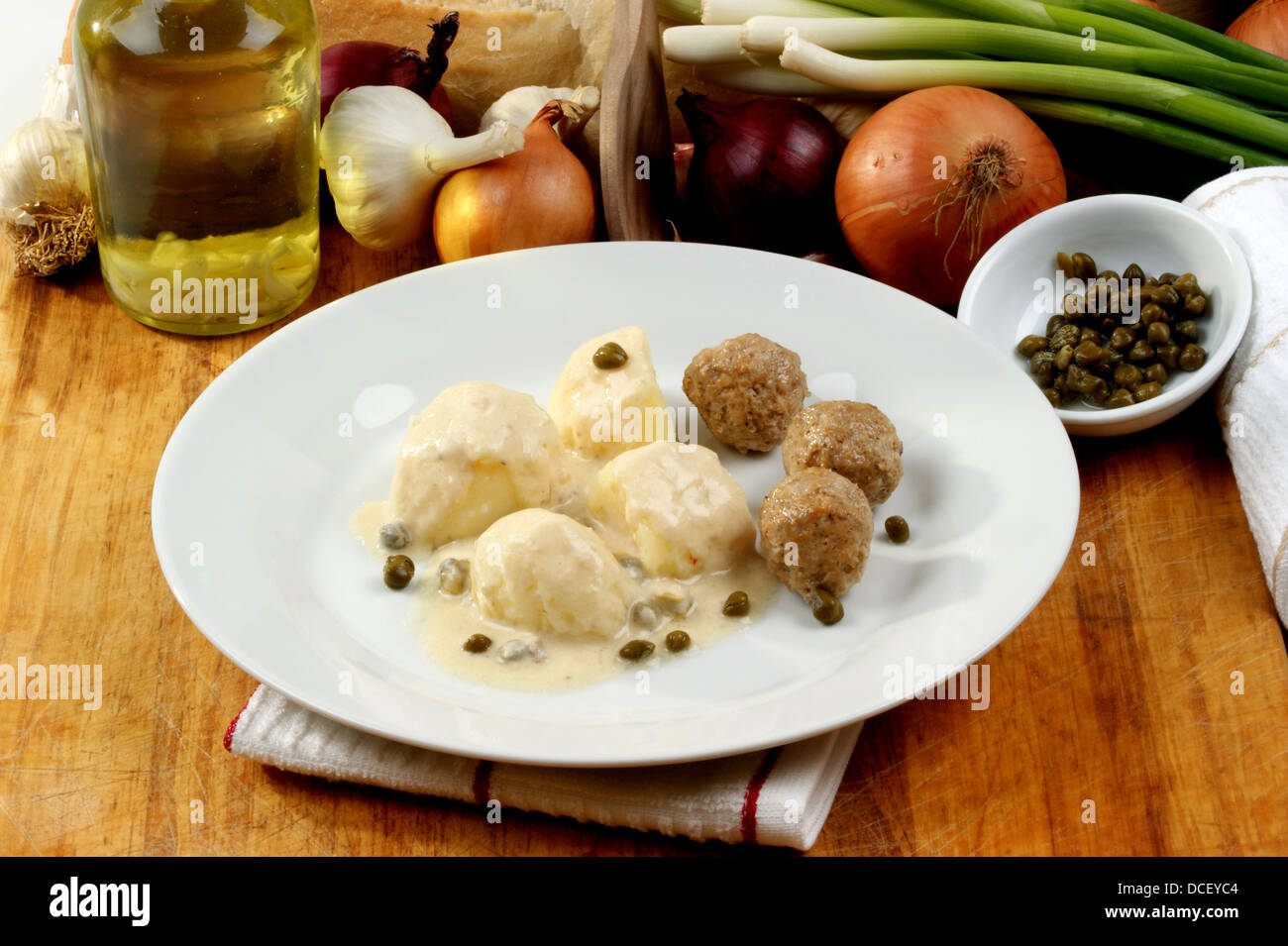 cooked meatballs in a white sauce with capers Stock Photo Alamy