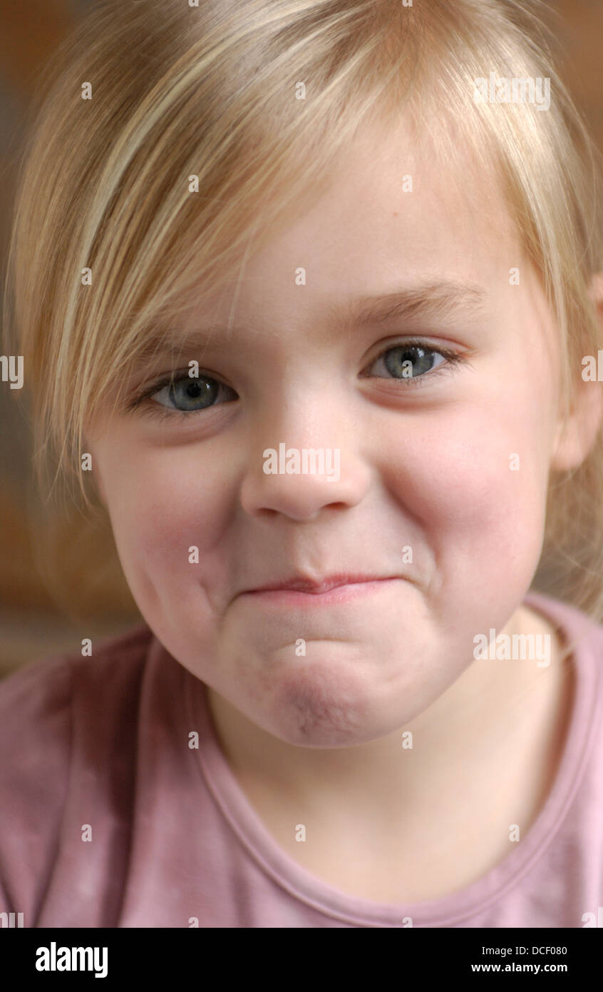 Portrait of a blond little girl with a shy expression Stock Photo - Alamy