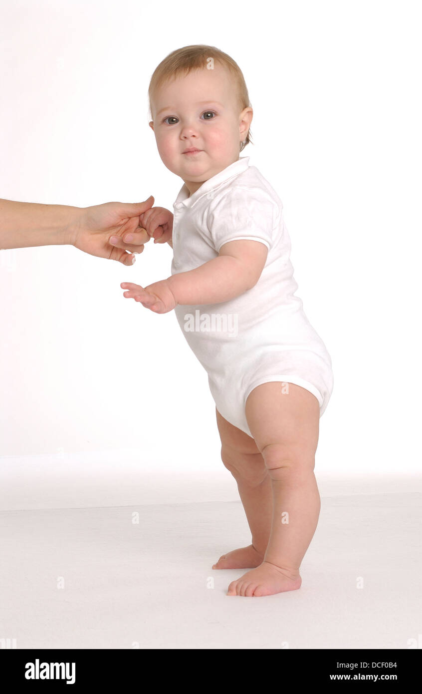 Little baby girl is trying to stand Stock Photo - Alamy