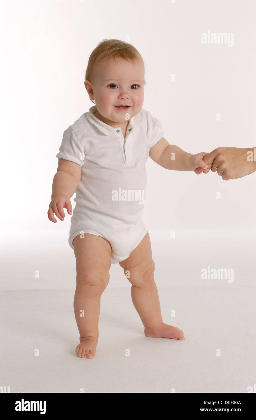 Little baby girl is trying to stand Stock Photo - Alamy