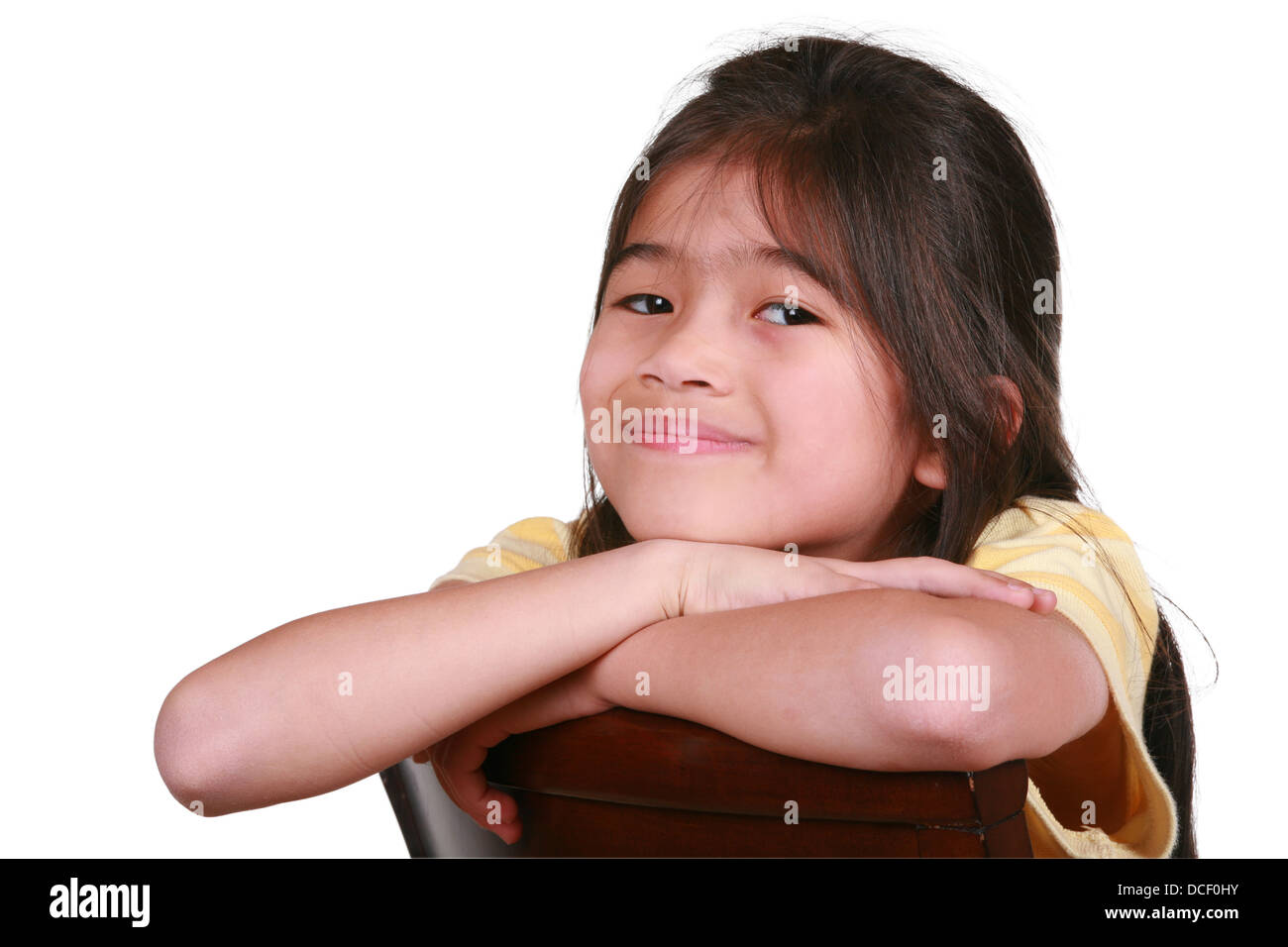 Beautiful little girl sitting on chair smiling Stock Photo - Alamy