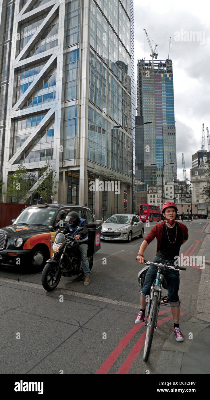 Cyclist waiting at traffic lights on Bishopsgate with a view of the Heron Tower and Leadenhall building London UK  KATHY DEWITT Stock Photo