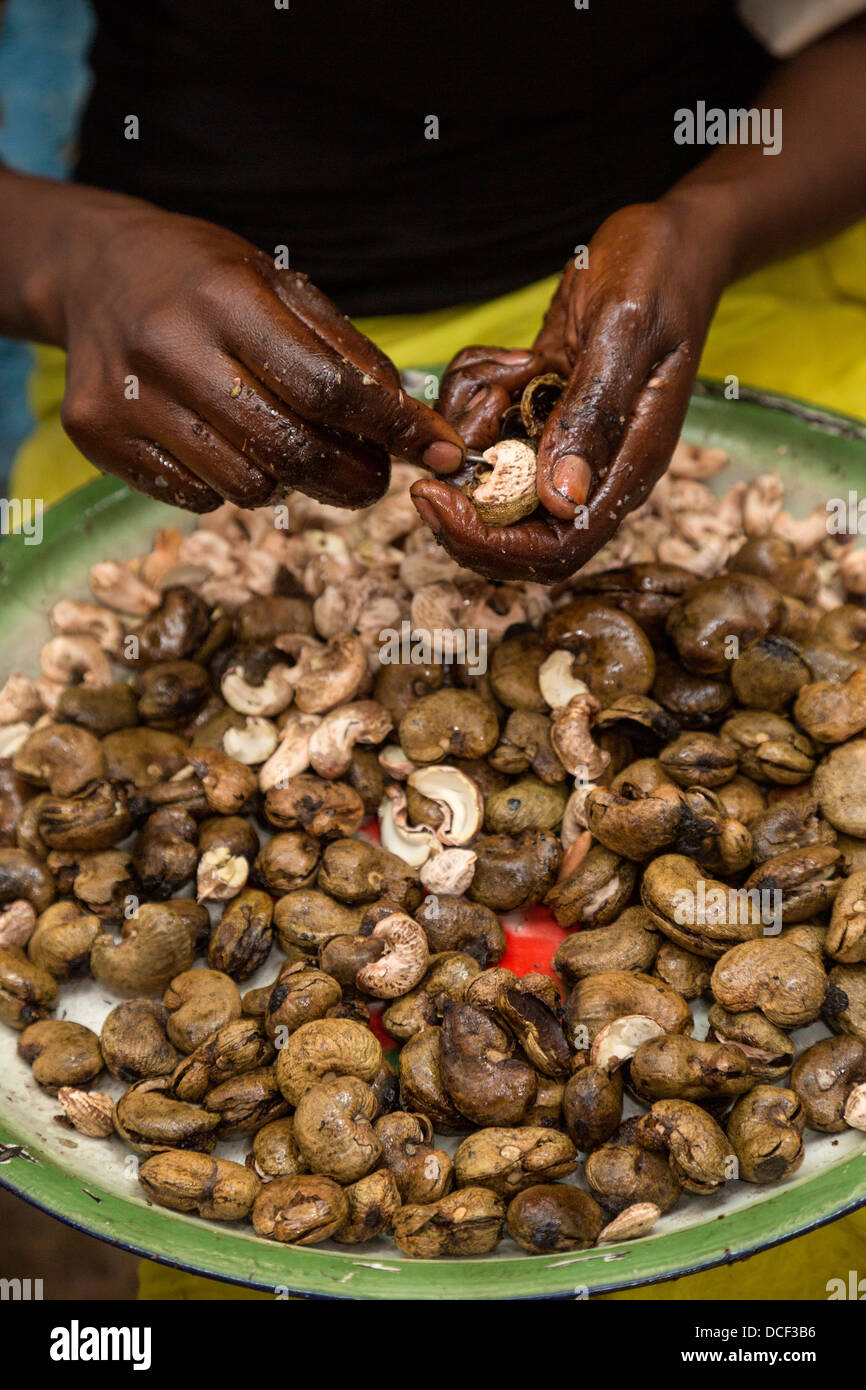 Woman Hulling Cashew Nuts. Group Juboo Cashew Processing Center, Fass Njaga Choi, North Bank Region, The Gambia Stock Photo