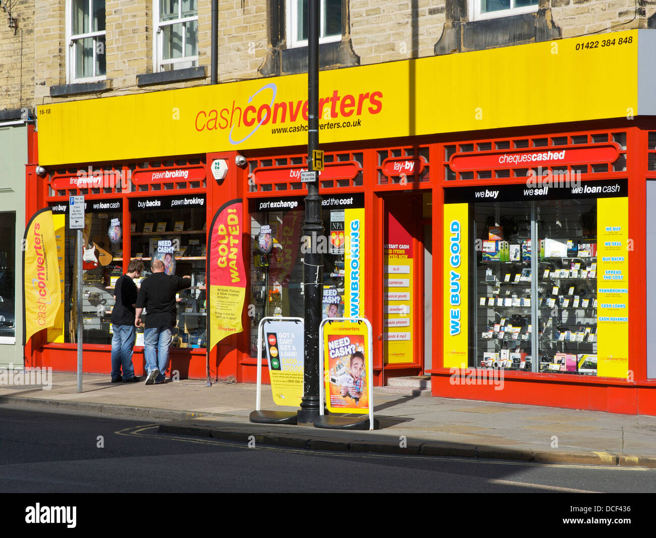 Two men looking in the window of Cash Converters, Waterhouse Street, Halifax, West Yorkshire, England UK Stock Photo