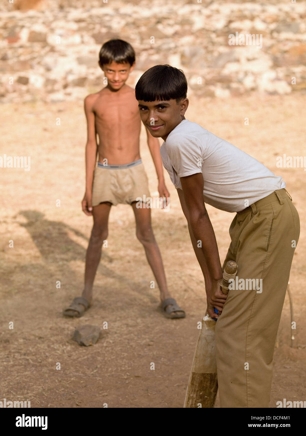 Two Boys Playing Cricket,Using Makeshift Equipment; Aravalli Hills,Rajasthan,India Stock Photo