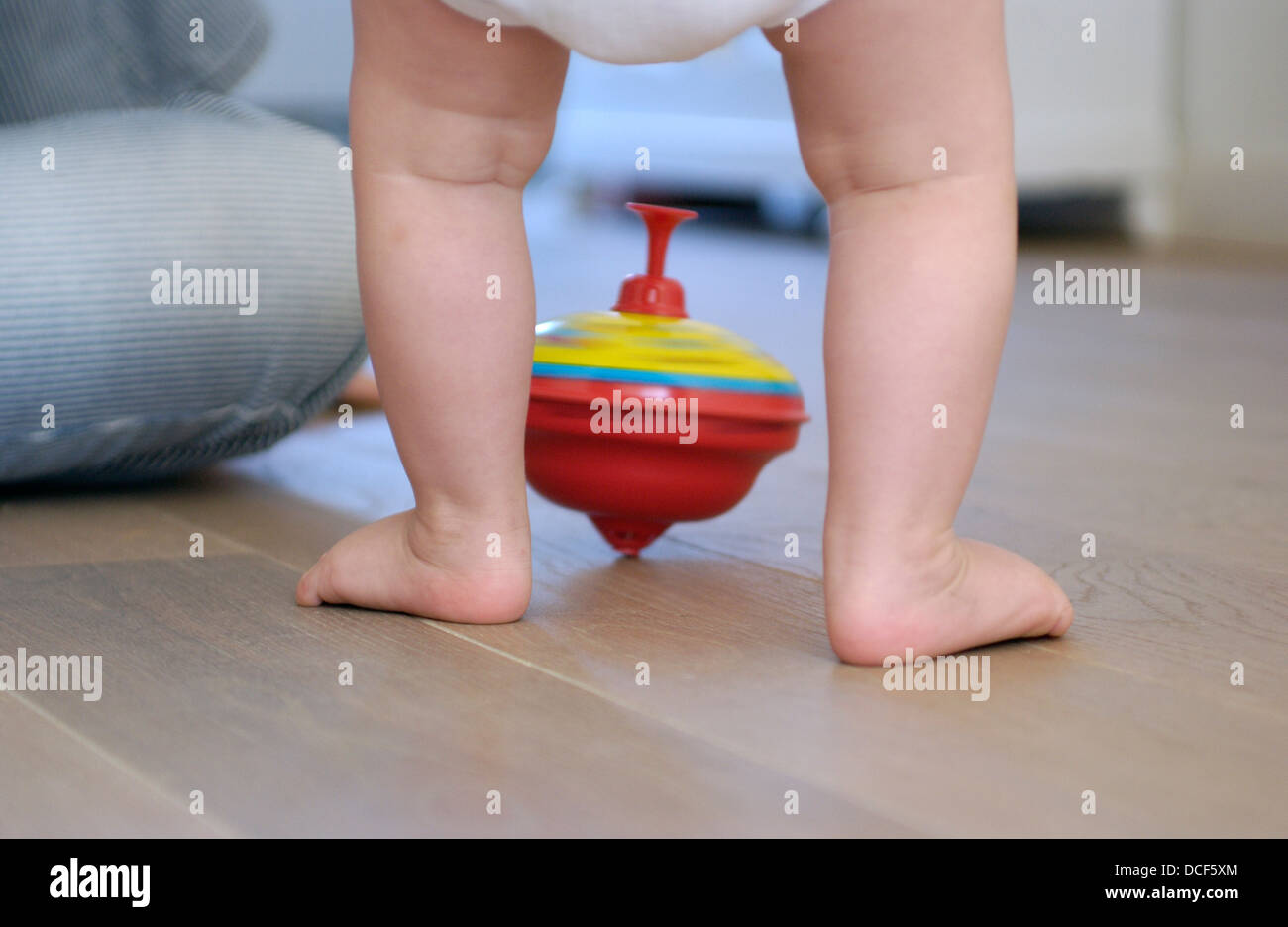 Toddlers feet and a humming top Stock Photo Alamy